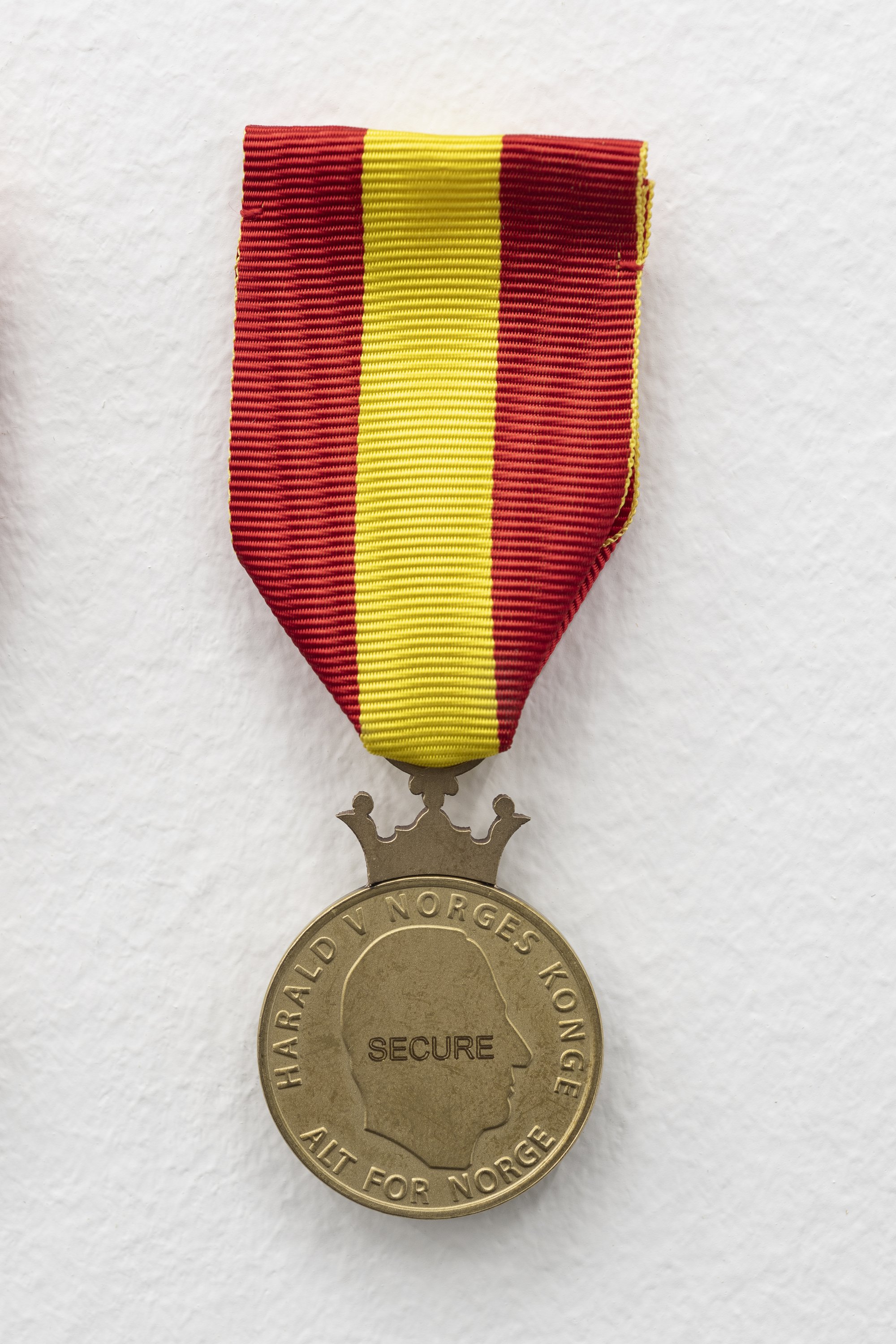 Sidsel Meineche Hansen, Secure, medal of merit, stamped in Nordic Gold with engraving and silk ribbon, 30 mm (diameter) - 35 mm (ribbon), 2021